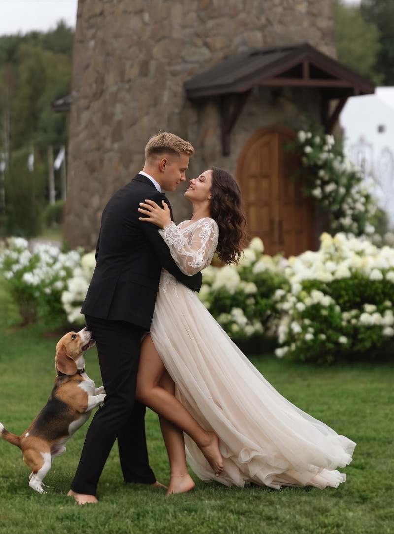 Novios bailando abrazados en el jardín mientras su beagle salta a su lado